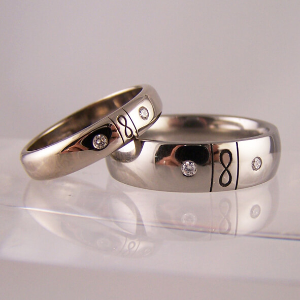His and hers diamond set infinity wedding rings in polished titanium